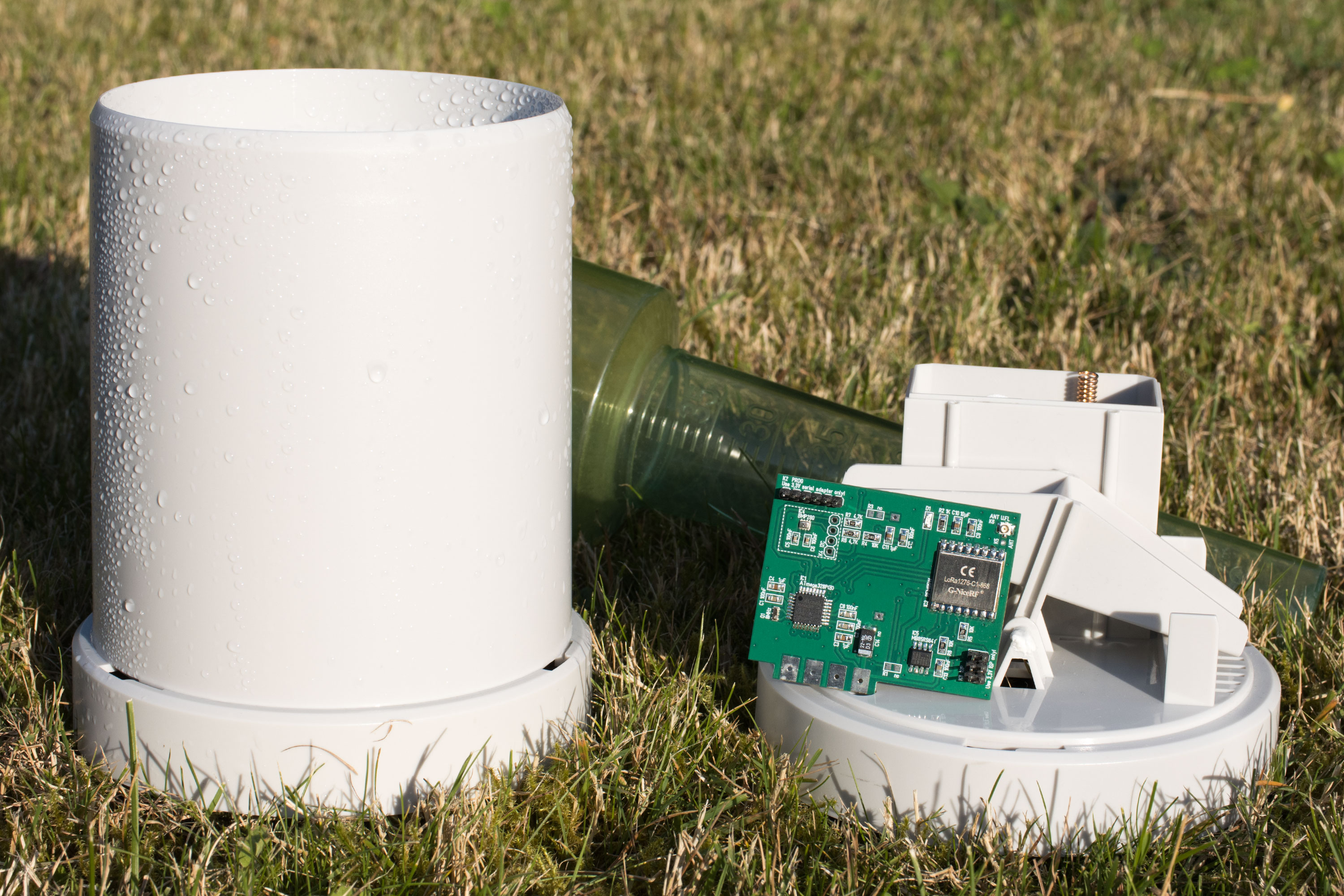 Two rain gauges and the printed circuit board outdoors